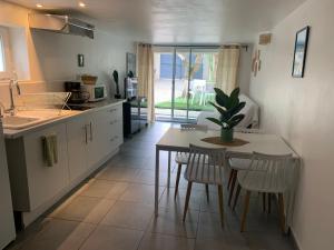 a kitchen with a table and a table and chairs at La bambouseraie de La mitre in Toulon +3 photos