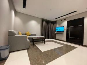 a living room with a couch and a tv at شقق درر رامه للشقق المخدومة 2 in Riyadh