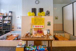 Kominka Guesthouse SENTŌ في Yakumo: غرفة بطاولة وساعة على الحائط