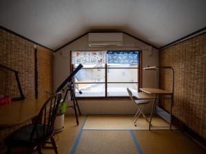 een kamer met een raam, een bureau en een tafel bij Kominka Guesthouse SENTŌ in Yakumo