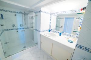 a white bathroom with a sink and a shower at House via Orlandi for 5 people in Anacapri