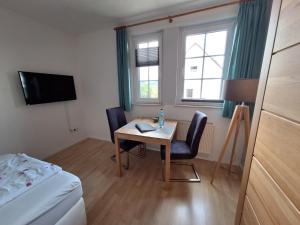 Habitación pequeña con mesa, sillas y cama en Wagener's Hof Apartments, en Bad Wildungen
