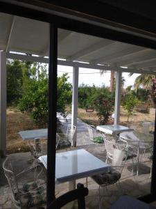un grupo de mesas y sillas en un patio en Violetta Hotel en Amoudara Herakliou
