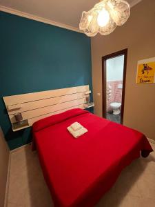 um quarto com uma cama vermelha e um cobertor vermelho em Mary Louise B&B em Roma
