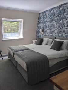 a bedroom with two large beds and a window at Loch Ness Drumnadrochit Hotel in Drumnadrochit