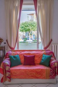 un sofá con almohadas sentado frente a una ventana en House via Orlandi for 5 people, en Anacapri