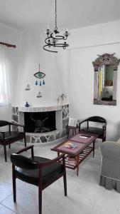 - un salon avec une cheminée, une table et des chaises dans l'établissement Arco In Pietra, à Apolakkiá