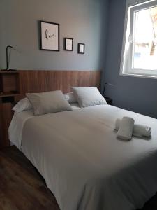 ein großes weißes Bett in einem Schlafzimmer mit Fenster in der Unterkunft NOARU Apartamentos in Ares