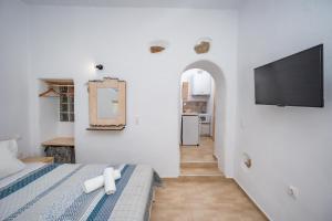 um quarto com uma cama e uma televisão na parede em Feel the Serenity 2 em Galini