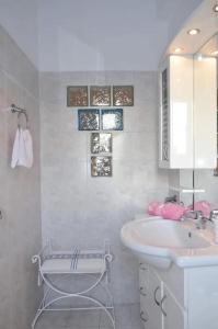 La salle de bains blanche est pourvue d'un lavabo et d'un miroir. dans l'établissement Arco In Pietra, à Apolakkiá