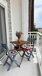 d'une table en bois et de deux chaises sur un balcon. dans l'établissement Arco In Pietra, à Apolakkiá