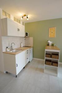 una cocina con armarios blancos y fregadero en Studio à 1min des plages, Juan les Pins, en Antibes