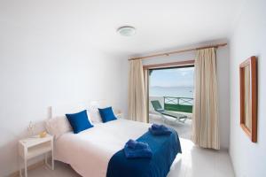 a bedroom with a bed and a view of the ocean at Blancazul Avenida in Playa Blanca
