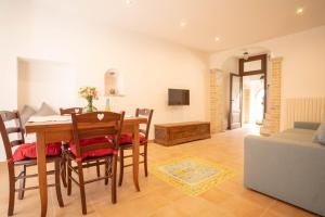 a dining room and living room with a table and chairs at La casetta in Tortoreto Lido