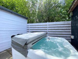 a hot tub in a backyard next to a fence at Hunters Hideaway-Hot Tub-Wiltshire-Groups in Warminster