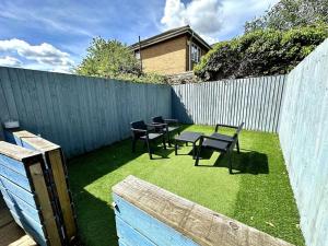 a backyard with chairs and a table and a fence at 2 Bedroom City Centre House - Pet Friendly - Free Parking in Cardiff