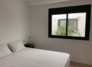 1 dormitorio con cama blanca y ventana en House of Maximus - High standing - Centre 90m2 en Torremolinos