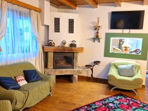 - un salon avec une cheminée, un canapé et une chaise dans l'établissement Clematis House, à Voroneț