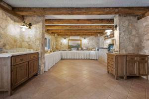 una grande cucina con armadi in legno e lavandino di Boutique Guesthouse Sveti Petar, on the beach, heated pool & boat berth - ADULT ONLY a Nečujam