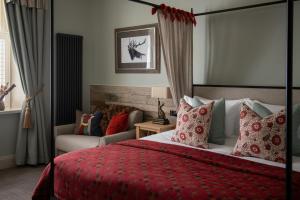 1 dormitorio con cama roja y sofá en The Golden Lion at Settle en Settle