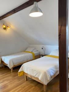 2 łóżka w pokoju z białymi ścianami i drewnianą podłogą w obiekcie Komfortowy Dom Bilard, Piłkarzyki, Gry Arcade w mieście Goniadz
