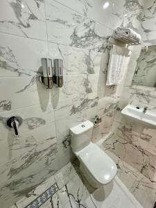 卡薩布蘭卡的住宿－The Hotel Syracuse，白色的浴室设有卫生间和水槽。