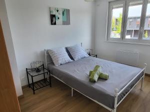a bedroom with a bed with two pillows on it at Maison THEB in Saint-André-lez-Lille