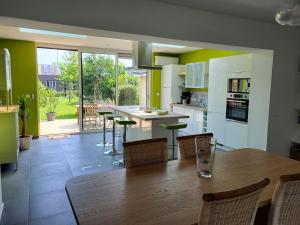 a kitchen with a large wooden table and chairs at Maison THEB in Saint-André-lez-Lille