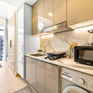 a kitchen with a stove top oven next to a dishwasher at Azizi Riviera 16 studio with Kitchenet - Ideal for monthly in Dubai
