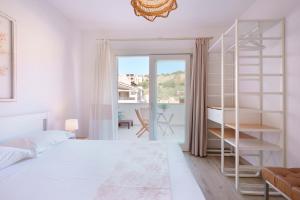 1 dormitorio con cama blanca y estante para libros en Domo Green House en Villasimius