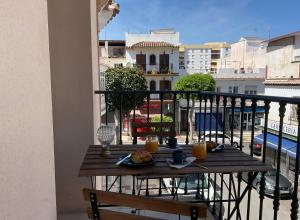 una mesa en un balcón con 2 vasos de zumo de naranja en House of Maximus - High standing - Centre 90m2 en Torremolinos