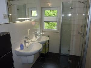 a bathroom with two sinks and a shower at Hilma in the holiday home Bero in Bärenwalde +14 photos