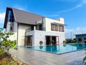 a house with a swimming pool in front of it at Liyadi Addalaichenai in Addalachenai