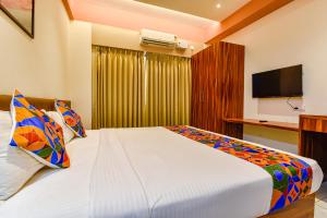 a bedroom with a large bed with a television at FabHotel Peak Stay in Porvorim
