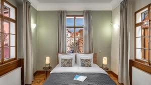 a bedroom with a bed and a large window at 3 Epoques Apartments by Adrez in Prague