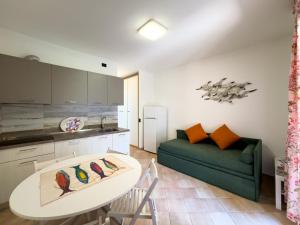 a living room with a table and a green couch at Appartamento Stefania Località Nisportino in Rio nellʼElba