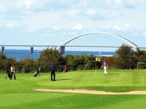 a group of people playing golf in front of a bridge at Mobile home "Romantic Suite" M 160 in Fehmarn +10 photos