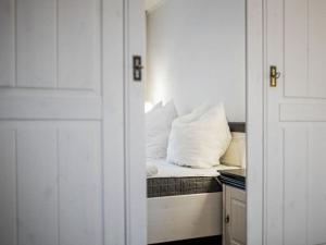 a room with a bed with white pillows on it at Strandeck Zuidstrand in Göhren