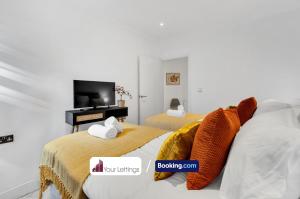 Duas camas num quarto com televisão em Cosy Modern Stay at St Mary's Nest Apartment By Your Lettings Short Lets & Serviced Accommodation Peterborough With Free WiFi and Parking em Huntingdon