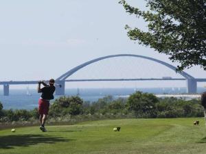 a man is taking a picture of a bridge at By the golf course in Wulfen on Fehmarn in Fehmarn