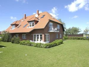 a large brown house with a grass yard at By the golf course in Wulfen on Fehmarn in Fehmarn