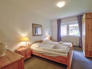 a bedroom with a large bed and a window at By the golf course in Wulfen on Fehmarn in Fehmarn +19 photos