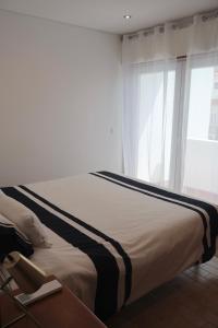 un letto in una stanza con una finestra di Moradia do Sal Albufeira - Vacation House near the Beach ad Albufeira