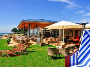 a restaurant with chairs and tables and umbrellas at on the beach no 991 in Wulfen auf Fehmarn