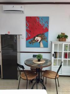 a kitchen with a table with chairs and a painting at Kallista Villa Kalibaru in Kalibaru +33 photos