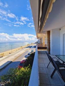 a balcony with a table and chairs and the beach at Viktoria Sea View Apartment in Perea