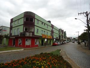 a building on the side of a street with flowers at Iria's Hotel in Timbó