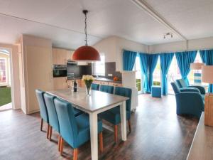 a kitchen and dining room with a table and blue chairs at Holiday House 177 Seeadler "Sea Eagle" type in Fehmarn