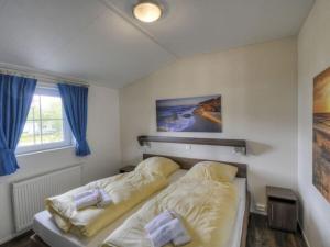 a bedroom with a bed and a window at Holiday House 177 Seeadler "Sea Eagle" type in Fehmarn +15 photos