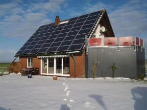 a house with solar panels on the roof at Nordzeeoase-Pethan met sauna in Neuharlingersiel